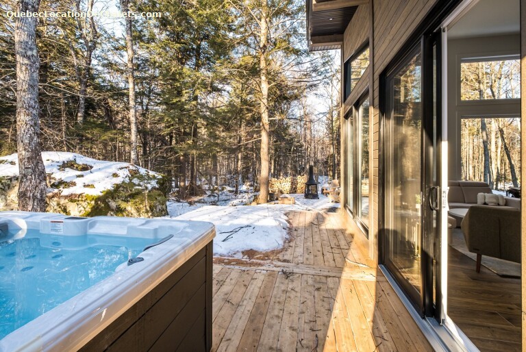 spa avec la neige qui fond au printemps à côté d'un chalet locatif